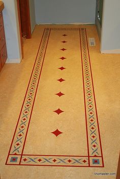 a long hallway with an intricate design on the floor and tile inlays to it