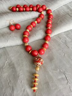 Coral Red Mountain Jade, 22 kt Gold Plated Beads, Coral 21" – Tru Original Designs Gold Dangling Beads For Festivals, Gold Temple Jewelry Beads With Dangling Details, Red Round Beads Mala As Gift, Red Round Beads Mala For Gift, Red Round Beads Jewelry For Festive Occasions, Red Mala With Round Beads For Gift, Festive Red Round Beads Jewelry, Red Beaded Necklace With Dangling Beads For Celebrations, Festive Gold Beaded Necklace With Large Beads