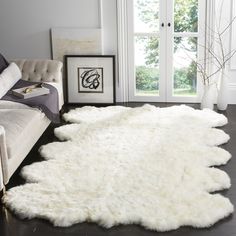 a living room with a white rug on the floor and a couch next to it