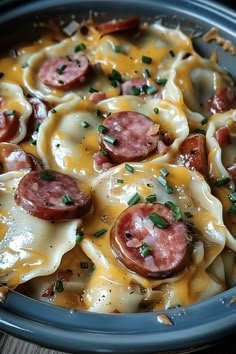 a close up of a plate of food with cheese and sausages on it's shells