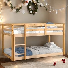 there is a bunk bed in the room with christmas decorations on the wall behind it