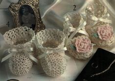 there are crocheted baby shoes and a photo frame next to it on the table