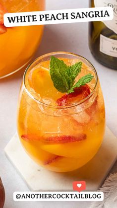 white peach sangria in a glass with mint garnish