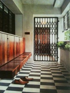 a pair of shoes sitting on the floor in front of a door with an iron screen