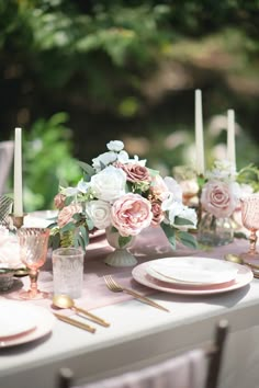 the table is set with pink and white flowers