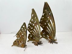 three metal butterflies sitting next to each other