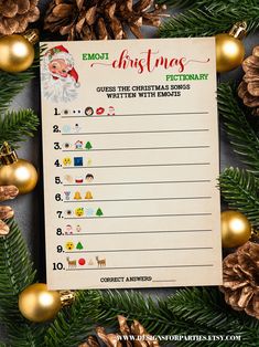 a printable christmas list with gold ornaments and pine cones on the table next to it