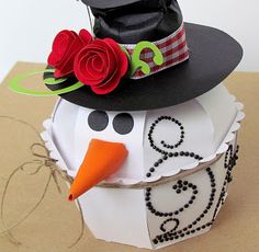 a paper snowman with a black hat and red roses