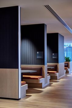 the interior of a restaurant with wooden benches and black walls, along with wood flooring