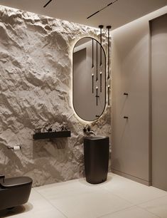 a modern bathroom with stone wall and round mirror