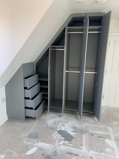 an attic closet with several drawers and shelves