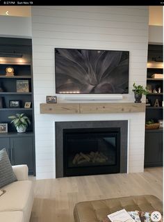 a large flat screen tv mounted on the wall above a fireplace in a living room