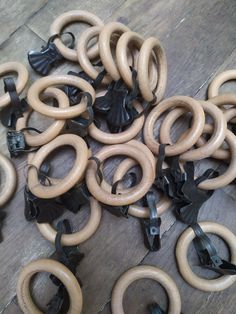 a pile of wooden rings on top of a wooden floor next to black metal handles