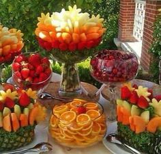 a table topped with lots of different types of fruits and veggie platters