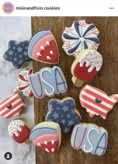 decorated cookies with the letter s on them are sitting on a wooden table next to an american flag