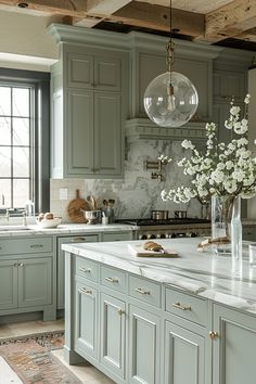 a kitchen filled with lots of green cabinets and white counter tops next to a window