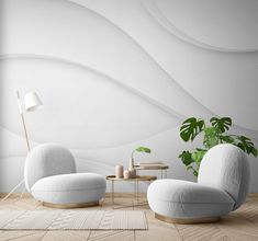 a living room with two white chairs and a coffee table in front of a plant