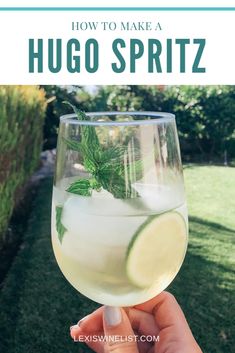 someone holding up a wine glass with a lime in it and the words how to make a hugo spritz