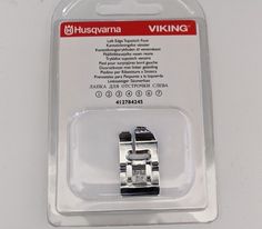 a pair of silver buckles sitting on top of a white table next to a packaged package