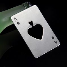 a bottle opener with a playing card shaped like a heart