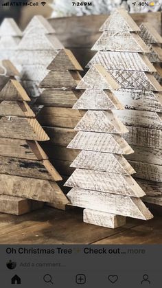 several wooden christmas trees sitting on top of a table in front of an iphone screen