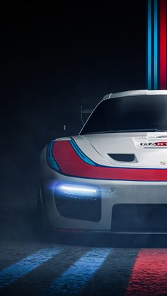 a white sports car with red and blue stripes on it's hood in the dark