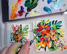 someone is painting flowers on canvases with watercolors