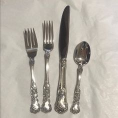 four silverware pieces with ornate designs on them, including forks and spoons sitting next to each other