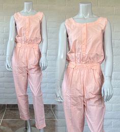 "Great find - three light cotton sleeveless jumpsuits, all new with the original tags! They're all pastel shades, including aqua, lilac, and orange. The jumpsuits have a henley placket with three buttons, an elastic waist also trimmed with buttons that can adjust the waist size, and a looser fit leg. They all have two hip pockets at the front and a plain back. The label reads Mister Noah - the orange and lilac jumpsuits have Noah hang tags and original price tags; the aqua one has the hang tag o Retro Cotton Jumpsuits And Rompers For Spring, Cotton Sleeveless Jumpsuit For Daywear, Cotton Sleeveless Jumpsuits And Rompers For Daywear, Sleeveless Cotton Jumpsuit For Daywear, Sleeveless Cotton Jumpsuits And Rompers For Daywear, Casual Cotton Jumpsuits And Rompers For Daywear, Cotton Overalls For Daywear, Lilac And Orange, Purple Jumpsuit