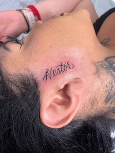 a man with a tattoo on his head has the word alesto written in black ink