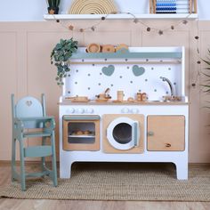 an old fashioned wooden toy stove and oven in a play room with toys on the floor