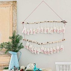 a table with a vase, potted plant and calendars hanging on the wall