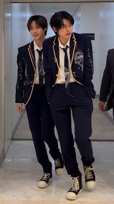 two young men dressed in suits and ties walking down an escalator with their feet on the ground