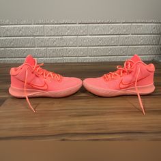 pair of pink nike shoes on wooden floor