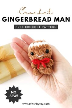 a hand holding a small crochet gingerbread man with a red bow around its neck