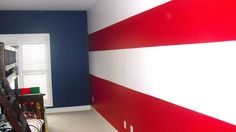 a bedroom with red and white stripes painted on the wall, along with bunk beds