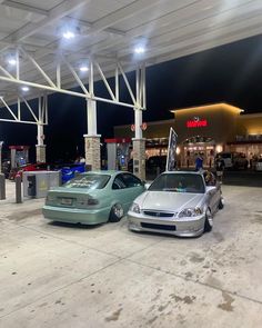 two cars parked in front of a gas station