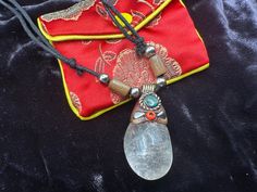 a piece of glass is sitting on top of a red cloth with an orange bead around it