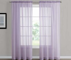 purple sheer curtains hanging on a wall in front of a window with an open curtain