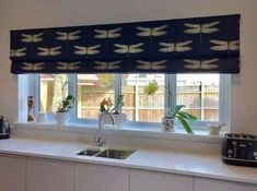 a kitchen with a sink, microwave and window sill in front of the counter