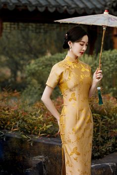 This luxurious gold silk qipao exudes elegance with its intricate floral and bird jacquard patterns, symbolizing beauty and prosperity. The rich golden hue radiates sophistication, making it a perfect choice for formal events, weddings, or cultural celebrations. Featuring a traditional mandarin collar and delicate frog button closures, the dress embraces classic Chinese design elements. Material: 40% Mulberry Silk, 60% Viscose Size Guide: Please note Asian size runs small, please check our size Elegant Gold Ao Dai For Wedding, Elegant Cheongsam With Stand Collar For Festive Season, Elegant Short Sleeve Ao Dai For Festive Occasions, Elegant Festive Cheongsam With Stand Collar, Elegant Gold Dress With Short Sleeves, Elegant Gold Dresses With Short Sleeves, Elegant Short Sleeve Gold Dresses, Formal Elegant Festive Cheongsam, Elegant Festive Formal Cheongsam