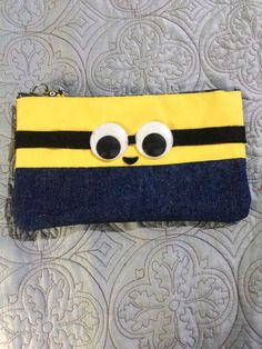 a small yellow and black purse with eyes