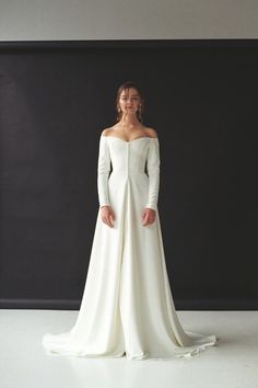 a woman in a white wedding dress posing for a photo with her hands on her hips