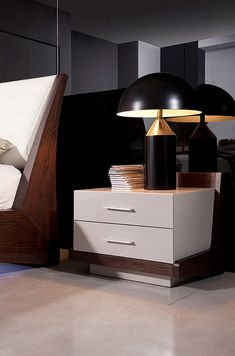 a bed with two lamps on top of it next to a night stand and dresser