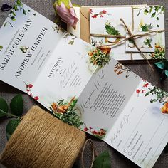 the wedding stationery is laid out on top of each other with twine and flowers