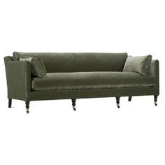 a green velvet couch with two pillows on it's arms and legs, against a white background