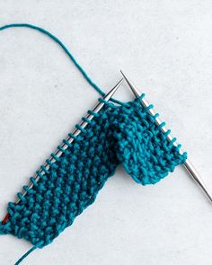 a blue knitted object with a crochet hook