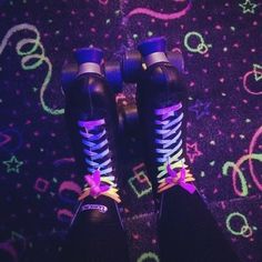 a person wearing purple and blue laces on their skates in front of a carpet