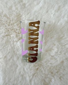 a clear glass with the word glamour on it sitting on a white furnishing