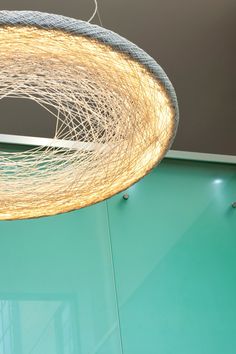 a light fixture hanging from the ceiling in a room with green walls and glass doors